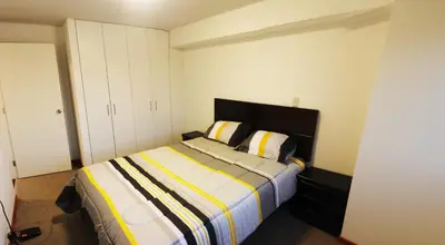 a bedroom with a bed with a striped blanket at Departamento Lima in Lima