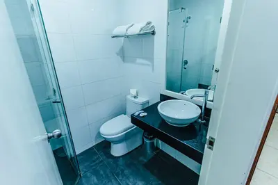 a bathroom with a toilet and a sink and a shower at Hotel Hacienda Lima Norte in Lima