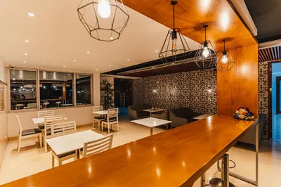a restaurant with a bar and tables and chairs at Hotel Hacienda Lima Norte in Lima