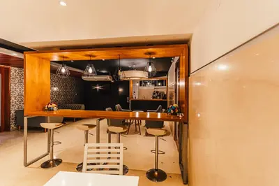 a kitchen and dining room with a bar and stools at Hotel Hacienda Lima Norte in Lima