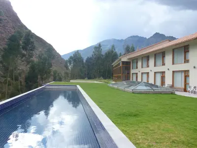 a swimming pool in a yard next to a building at Taypikala Deluxe Valle Sagrado in Urubamba