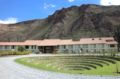 a building with a mountain in the background with a large labyrinth at Taypikala Deluxe Valle Sagrado in Urubamba