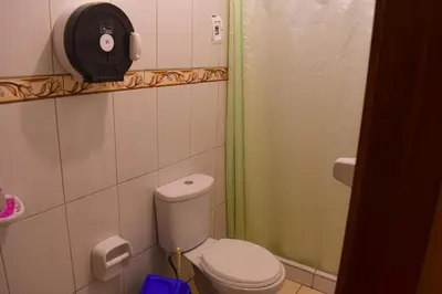 a small bathroom with a toilet and a shower at Passion Hostel - Barranco in Lima