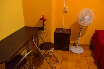a room with a desk with a fan and a chair at Passion Hostel - Barranco in Lima