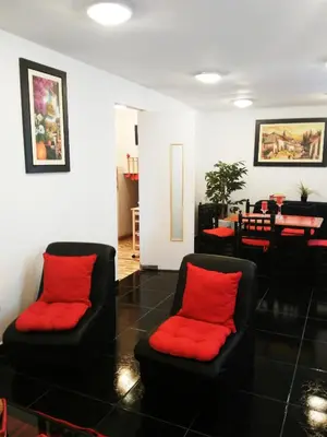 two black chairs with red pillows in a living room at White Hope Apartment in Lima