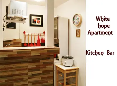 a kitchen with a white stove and a kitchen bar at White Hope Apartment in Lima