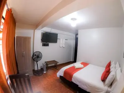 a bedroom with a bed and a flat screen tv at Machu Picchu Land in Machu Picchu