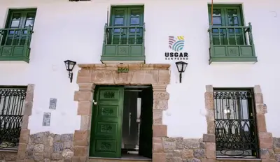 a building with green doors and windows at Usgar San Pedro Boutique in Cusco