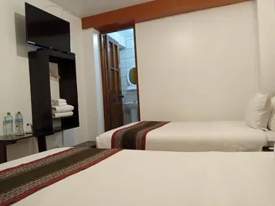 a hotel room with two beds and a window at Inkas Land in Machu Picchu