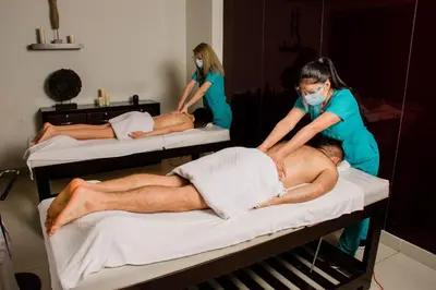 a man getting a massage on a bed with two women at Hotel Miramar in Lima