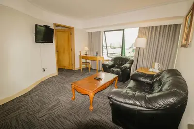 a living room with a leather couch and a table at Hotel Miramar in Lima