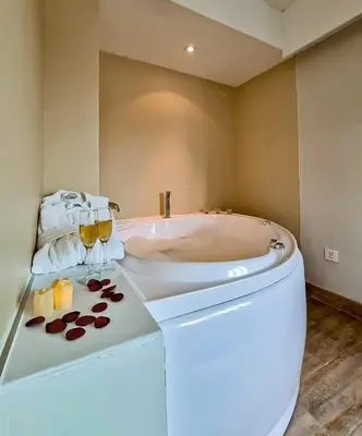 a bathroom with a tub and a toilet and glasses of wine at Hotel Miramar in Lima