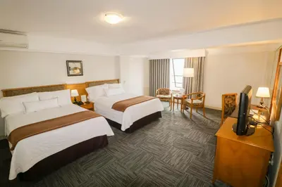 a hotel room with two beds and a flat screen tv at Hotel Miramar in Lima