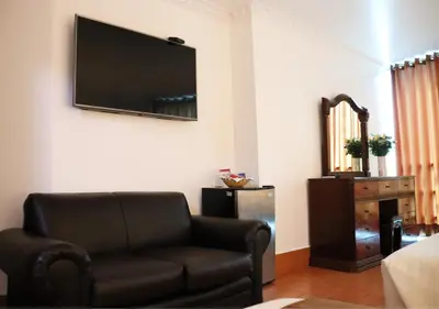a living room with a couch and a flat screen tv at Inkari Suites Hotel in Lima