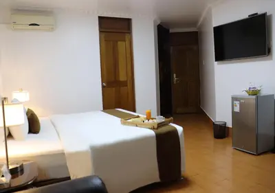 a hotel room with a bed and a flat screen tv at Inkari Suites Hotel in Lima