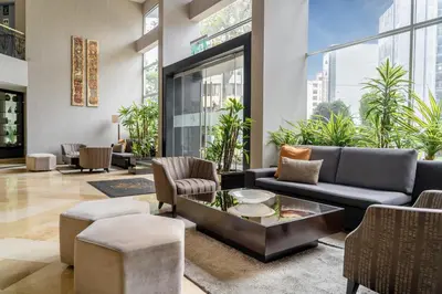 a lobby with a couch and chairs and a table at Hotel Jose Antonio in Lima