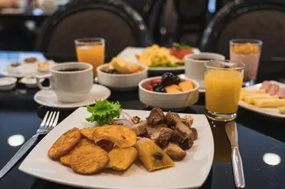 a table topped with plates of food and orange juice at Hotel Jose Antonio in Lima