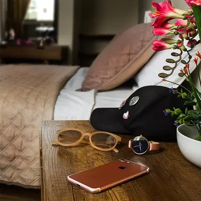 a table with a cell phone and glasses on a bed at Montreal Hostal in Lima