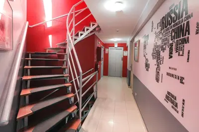 a hallway with stairs in a building with red walls at Hotel Boutique Runcu Miraflores in Lima