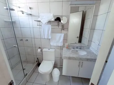 a white bathroom with a toilet and a sink at Hotel Boutique Runcu Miraflores in Lima