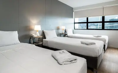 a hotel room with three beds with towels on them at Miraflores Suites Centro in Lima