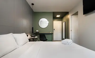 a bedroom with a white bed and a mirror at Miraflores Suites Centro in Lima