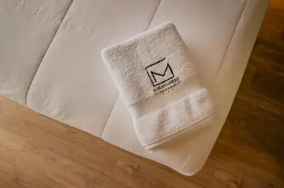 a white towel sitting on top of a bed at Miraflores Suites Centro in Lima