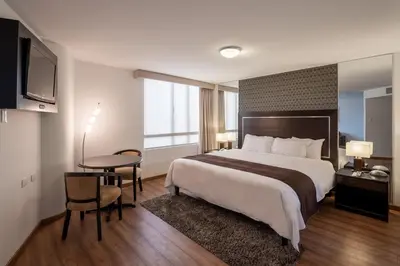 a hotel room with a large bed and a table at Jose Antonio Executive in Lima