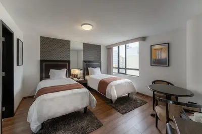 a hotel room with two beds and a table at Jose Antonio Executive in Lima