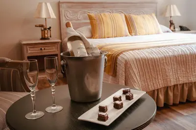 a table with two glasses and a bottle of wine and brownies at Hotel Antigua Miraflores in Lima