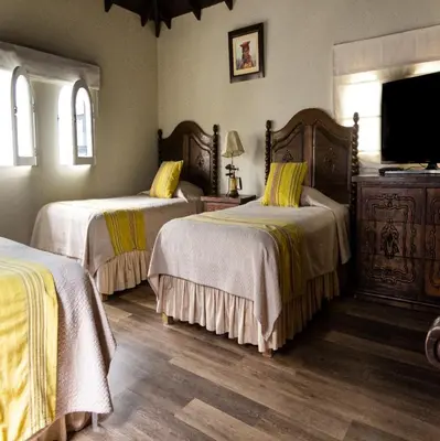 a bedroom with two beds and a flat screen tv at Hotel Antigua Miraflores in Lima