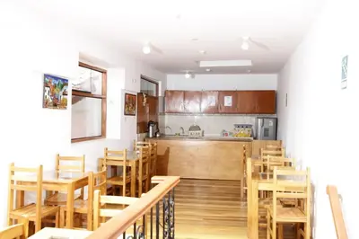 a kitchen and dining room with wooden tables and chairs at Casa Union Cusco in Cusco