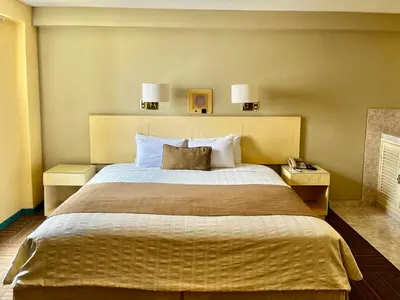 a bedroom with a large bed with two lamps on the wall at Embajadores Hotel in Lima