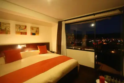 a bedroom with a bed and a window with a view at Hotel Encantada Casa Boutique Spa in Cusco