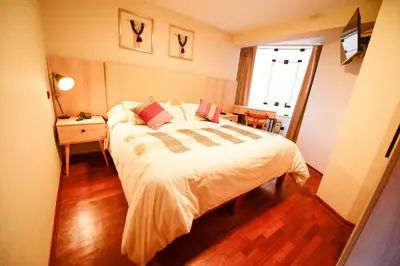 a bedroom with a large bed and a window at Torre Dorada Cusco in Cusco