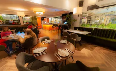 a restaurant with a table and people sitting at tables at Roosevelt Hotel & Suites in Lima