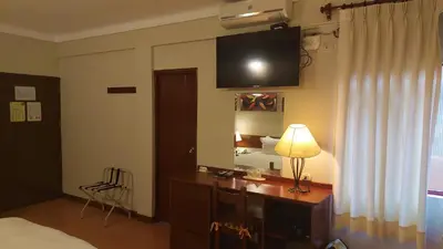 a bedroom with a desk and a television on the wall at Lima Wasi Hotel Miraflores in Lima
