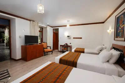 a hotel room with two beds and a flat screen tv at Hotel Hacienda Cusco Plaza in Cusco