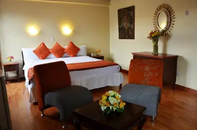 a hotel room with a bed and a chair at Nodo Cusco Santa Teresa in Cusco