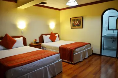 a hotel room with two beds and a sink at Nodo Cusco Santa Teresa in Cusco
