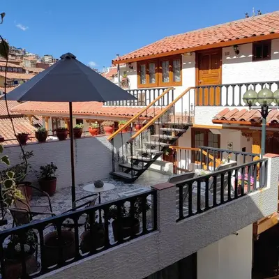 a balcony with a table and an umbrella at Hotel Rumi Punku in Cusco