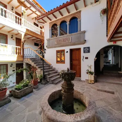 a courtyard with a fountain in front of a building at Hotel Rumi Punku in Cusco