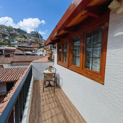 a small table on the balcony of a house at Hotel Rumi Punku in Cusco