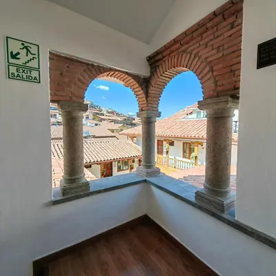 a balcony with three arches and a view of the city at Hotel Rumi Punku in Cusco