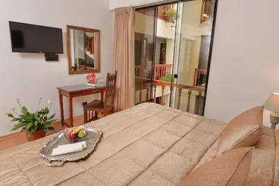 a bedroom with a bed with a tray of fruit on it at Hotel Ruinas in Cusco