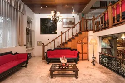 a living room with a red couch and a table at Hotel Ruinas in Cusco