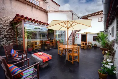 a patio with a table and chairs and an umbrella at Hotel Boutique Gold Garden in Cusco