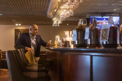 a man in a suit sitting at a bar at Casa Andina Premium Miraflores in Lima