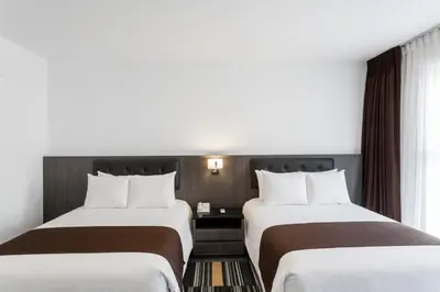 a hotel room with two beds and a window at Wyndham Costa del Sol Lima Airport in Lima