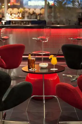 a table with red chairs and a table with drinks on it at Wyndham Costa del Sol Lima Airport in Lima